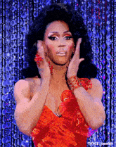 a drag queen in a red dress is making a funny face .