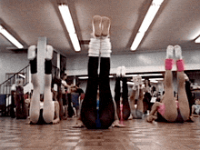 a group of people doing exercises with their legs up in a gym