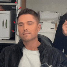 a man wearing a leather jacket and a white shirt