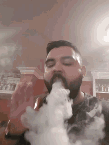 a man with a beard is smoking a hookah in a kitchen