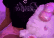 a woman in a black shirt is holding a stuffed hello kitty rabbit .