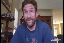 a man with a beard is wearing a blue shirt that says mpl