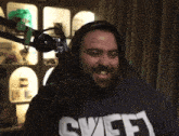 a man wearing headphones and a shirt that says ' sweep ' on it