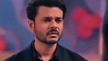 a close up of a man with a beard and mustache making a sad face .