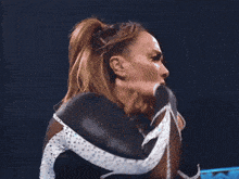 a woman in a black and white leotard is standing in a ring