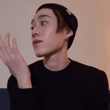 a young man wearing a beanie and a black shirt