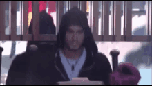 a man in a hooded jacket is sitting at a table