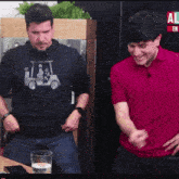 a man in a red shirt is standing next to another man in a black shirt