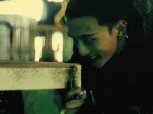 a man with piercings on his ears is smiling and looking at something