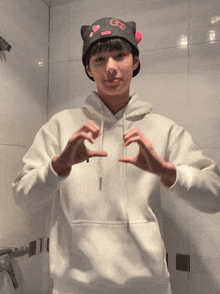 a person wearing a white hoodie and a black hat with gs on it