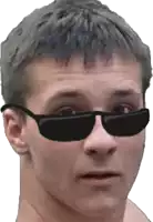 a man wearing sunglasses looks at the camera with a serious look on his face
