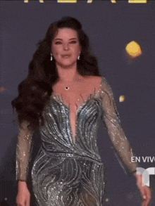 a woman is walking down a runway in front of a sign that says en vivo