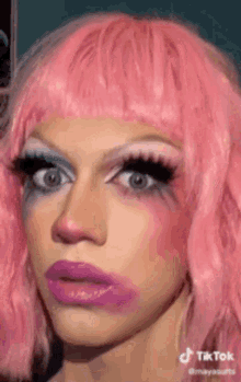 a close up of a woman wearing a pink wig and makeup