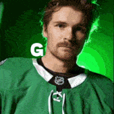 a man wearing a green nhl jersey with the letter g behind him