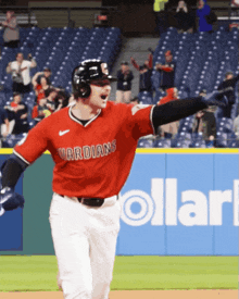a baseball player wearing a red jersey that says guardians on it