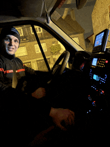 a man sitting in a car with a sticker on the windshield that says " emergency exit "