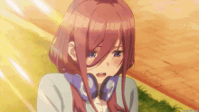 a close up of a girl with headphones on her neck