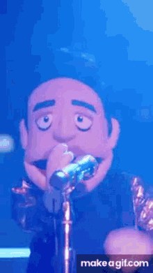 a puppet is singing into a microphone while standing on a stage .