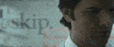 a close up of a man 's face with the word skip behind him