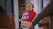 a man in a red crop top with a cat on it