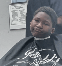 a young boy is getting a haircut at gerald 's barber shop