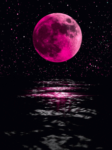 a pink full moon is reflected in the water at night