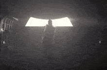 a man covering his eyes with his hand while standing in a dark room