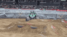 a monster jam truck is driving down a dirt road