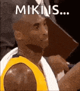 a basketball player is sitting in the stands with a towel around his neck and a towel around his neck .