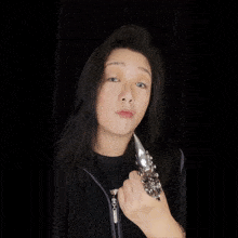 a woman with long black hair wearing a silver ring