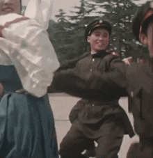 a man in a military uniform is dancing with a woman