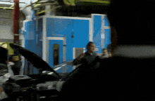 a blurry picture of a man standing in front of a blue building