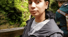 a woman wearing a nike shirt is standing on a bridge