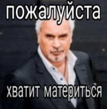a man in a suit and tie is standing in front of a black wall with a foreign language caption .