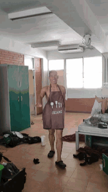 a man wearing a brown apron that says cooking on it