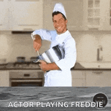 a man in a chef 's uniform is holding a pot and a knife in a kitchen .
