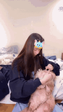 a woman is petting a small brown dog while wearing a blue headband with ears