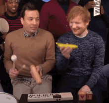 jimmy fallon and ed sheeran are playing instruments in a crowd
