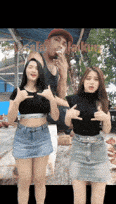 a man is smoking a cigarette while two women pose for a picture