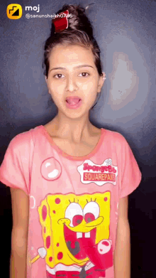a girl wearing a spongebob squarepants shirt is making a funny face