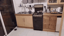 a kitchen with a stove and a sink with a bowl on the floor