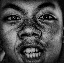 a black and white photo of a man 's face with a big smile