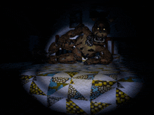 a teddy bear is laying on a bed with a quilt on it