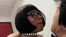 a woman wearing glasses and a wig looks at a man 's face