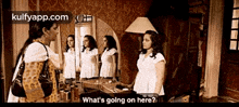 two women are standing in front of a mirror talking to each other and one of them is asking what 's going on here .
