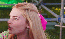 a woman with long blonde hair is wearing a pink headband .