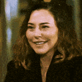 a woman with a nose ring and a black jacket smiles