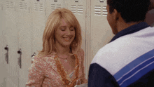 a man and a woman standing in front of lockers