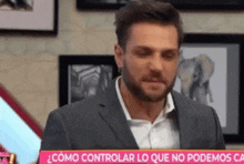 a man in a suit is holding a sign that says " como controlar lo que no podemos ca "