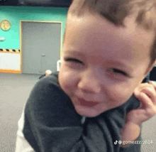 a young boy is smiling and looking at the camera while being held by a person .